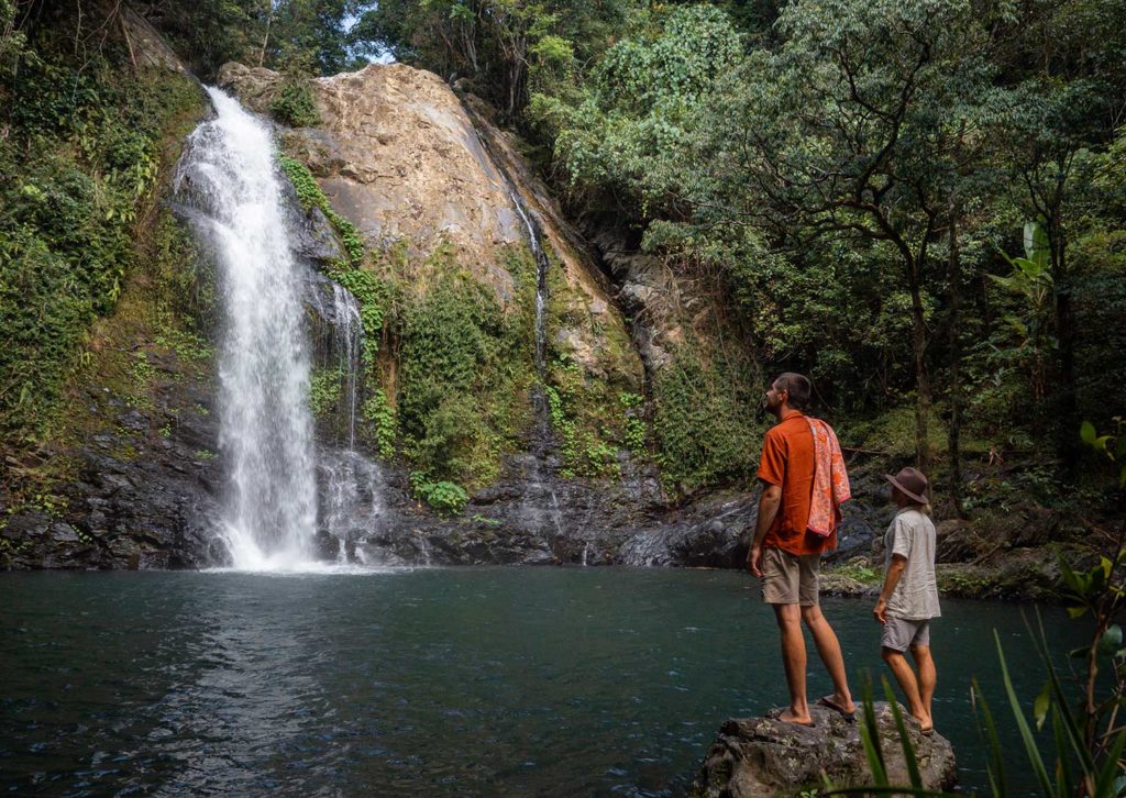 man and woman stood on rock at Cassowary Falls in the Daintree