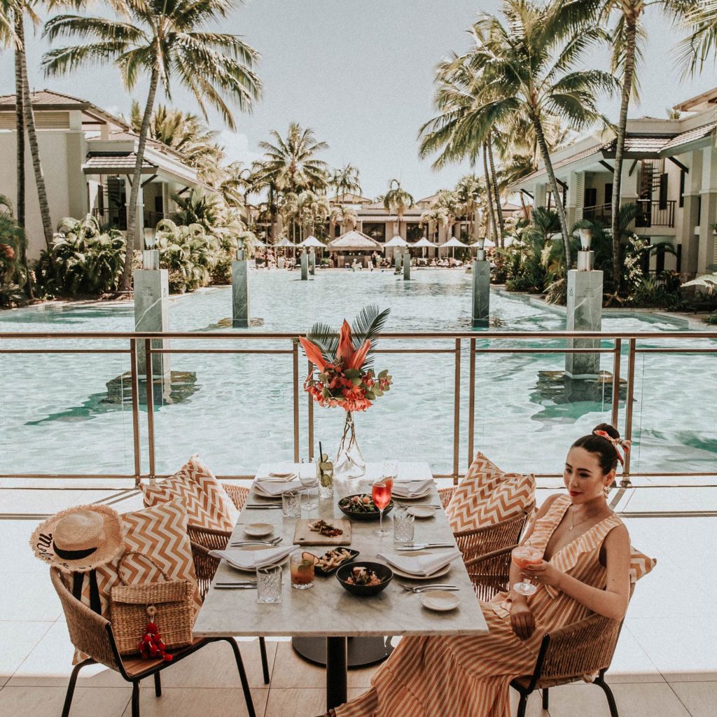 woman dining at pool at Pullman Port Douglas Sea Temple